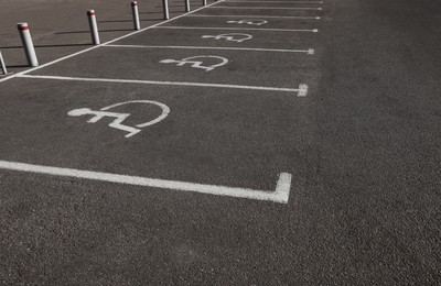 Photo of Car parking lot with wheelchair symbols outdoors