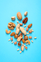 Flat lay composition with different nuts on light blue background