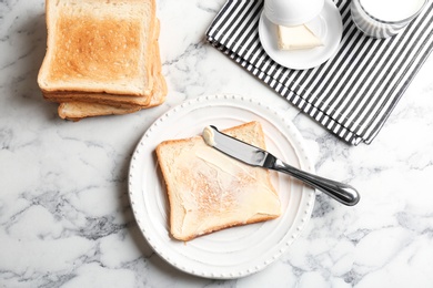 Photo of Plate with toasted bread and butter on table, top view