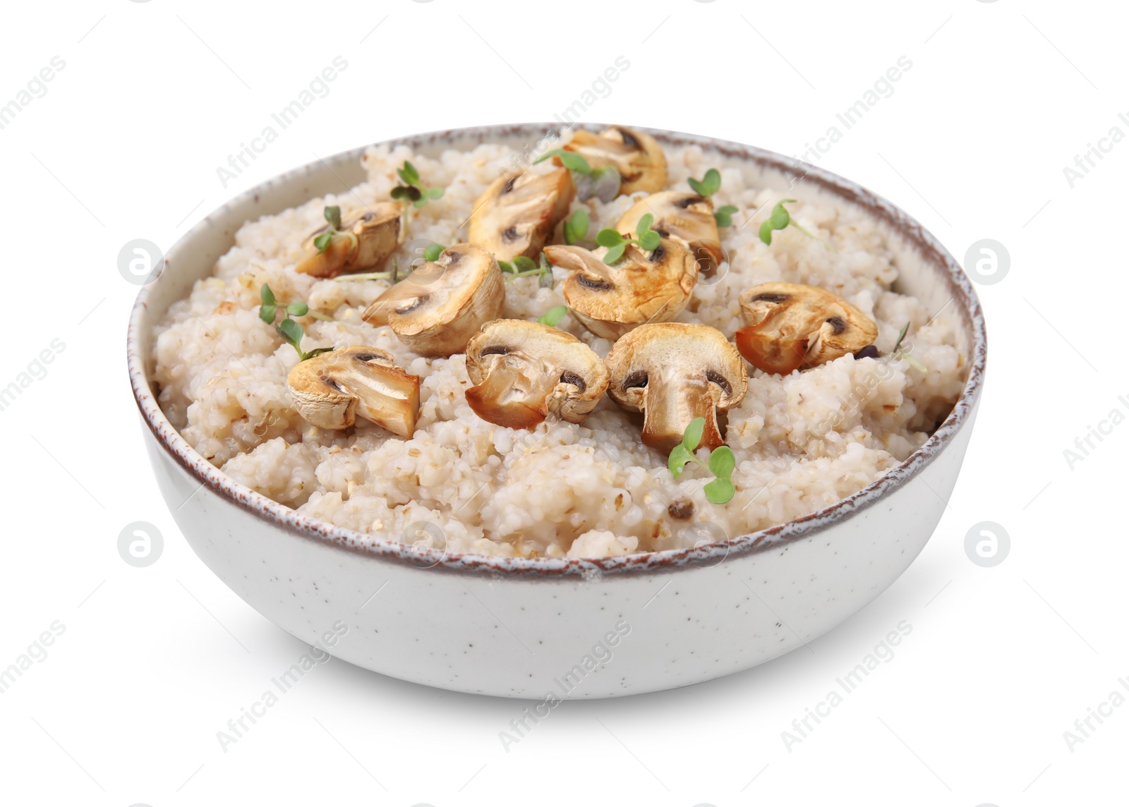 Photo of Delicious barley porridge with mushrooms and microgreens in bowl isolated on white