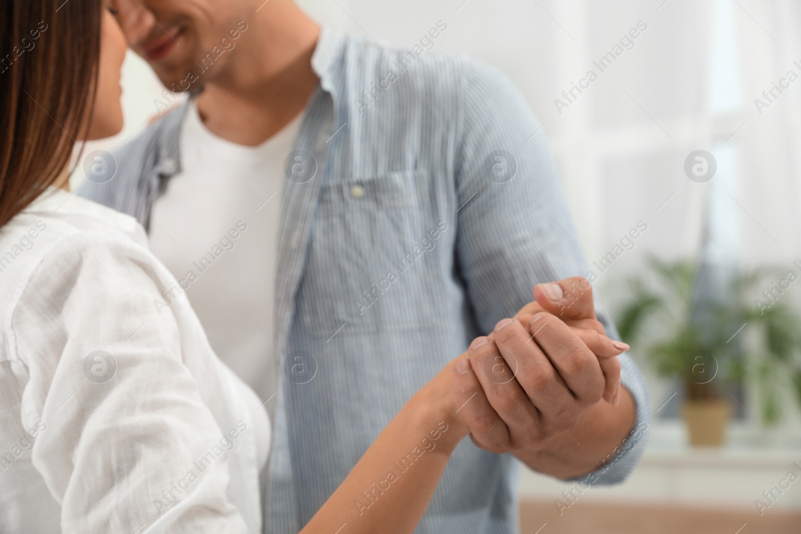 Photo of Happy young couple dancing together at home, closeup