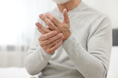 Photo of Arthritis symptoms. Man suffering from pain in hand at home, closeup