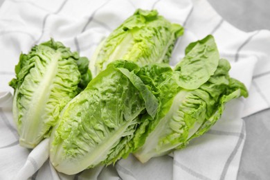Photo of Fresh green romaine lettuces on grey table, closeup