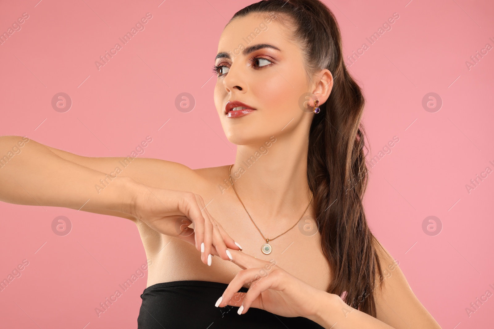 Photo of Beautiful woman with elegant jewelry on pink background