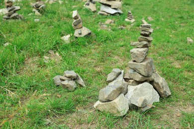Photo of Many stacked stones on green grass outdoors, space for text