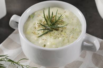 Delicious cream soup with tarragon, spices and potato in bowl on table, closeup