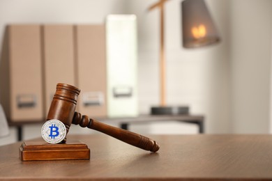 Photo of Law concept. Gavel and bitcoin on wooden table, space for text