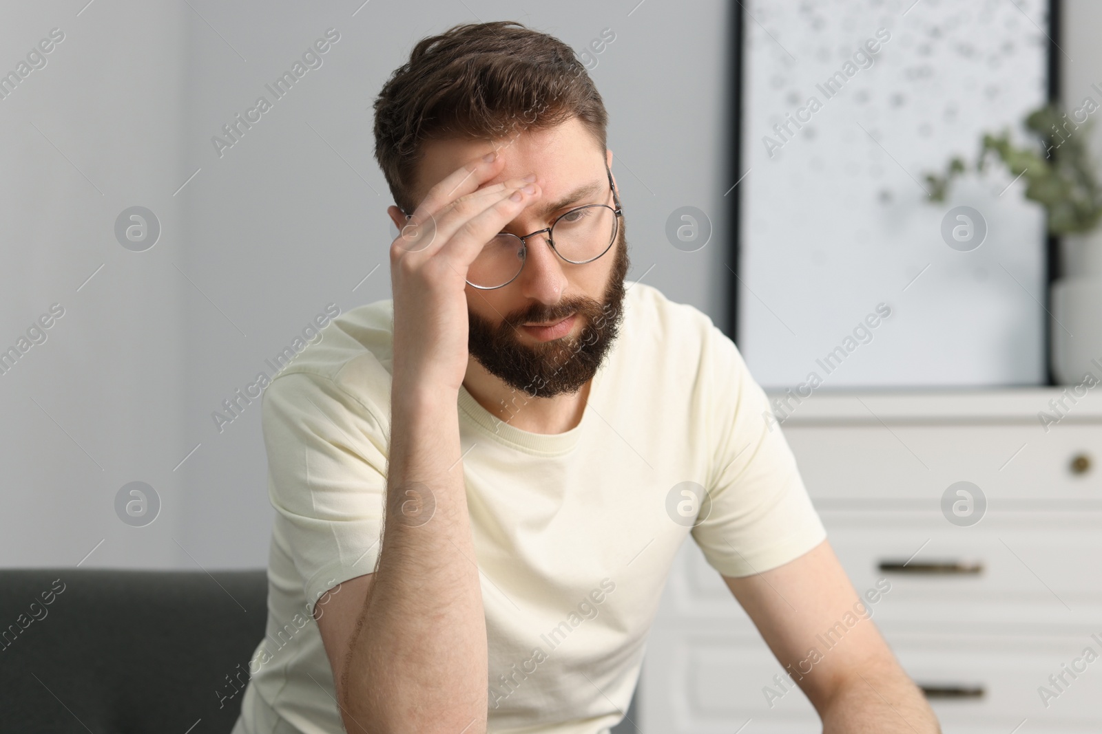 Photo of Overwhelmed man in glasses suffering at home