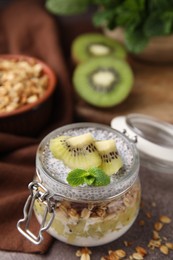 Delicious dessert with kiwi and chia seeds on brown table, closeup