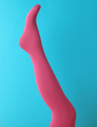 Photo of Leg mannequin in pink tights on blue background