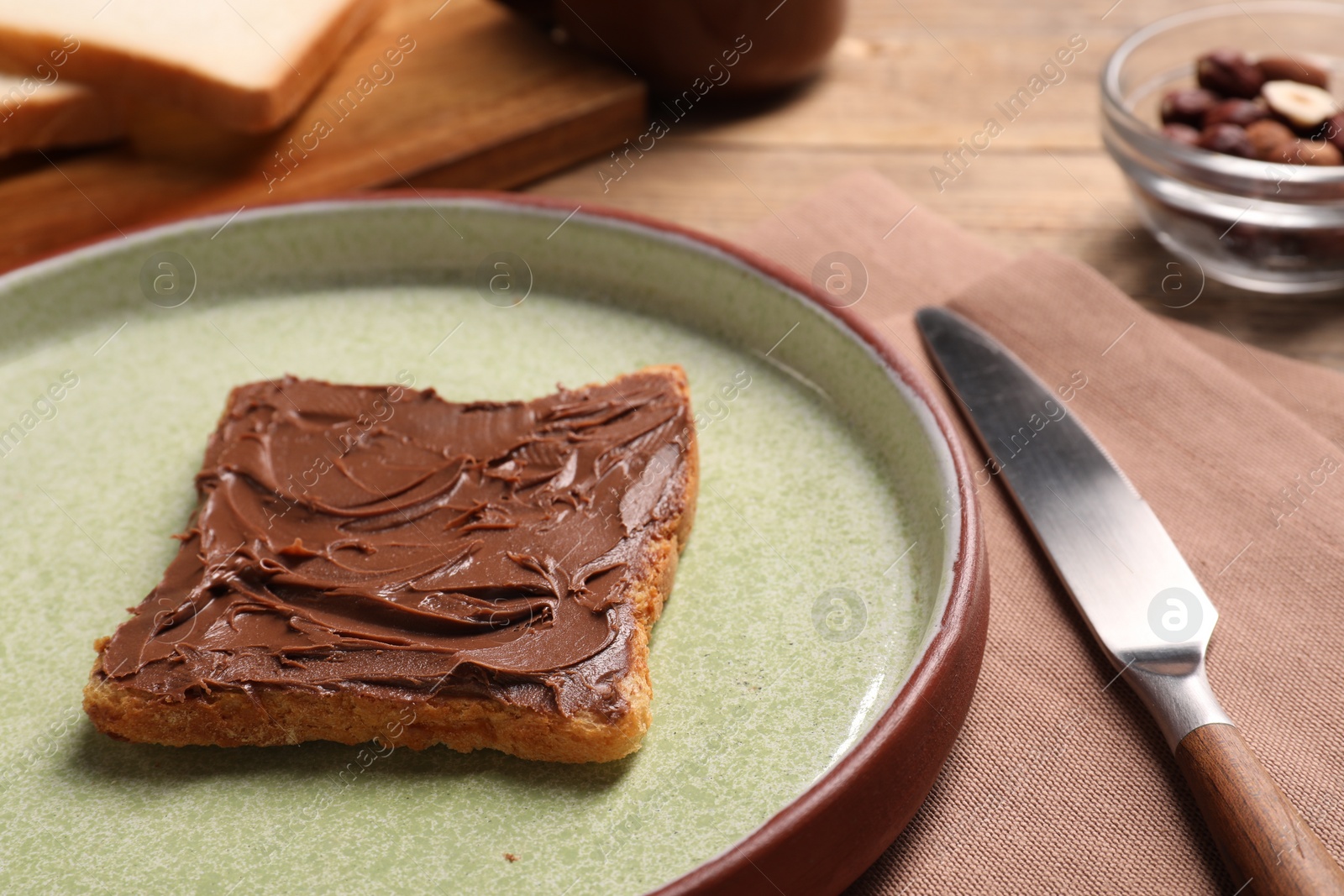 Photo of Toast with tasty nut butter and knife on table, closeup