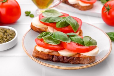 Photo of Delicious Caprese sandwiches with mozzarella, tomatoes and basil on white table, closeup