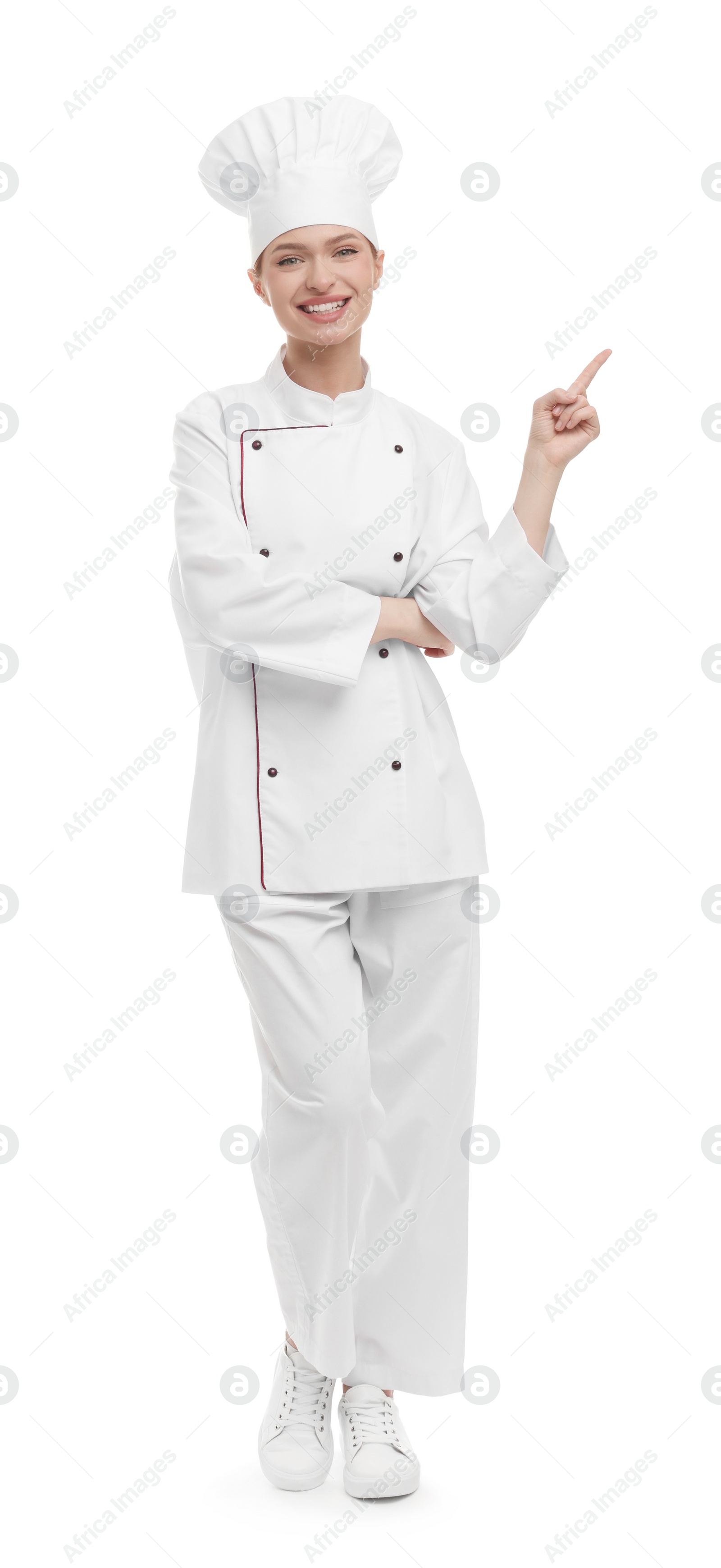 Photo of Happy woman chef in uniform pointing at something on white background