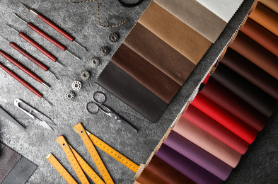 Photo of Flat lay composition with leather samples and craftsman tools on grey stone background