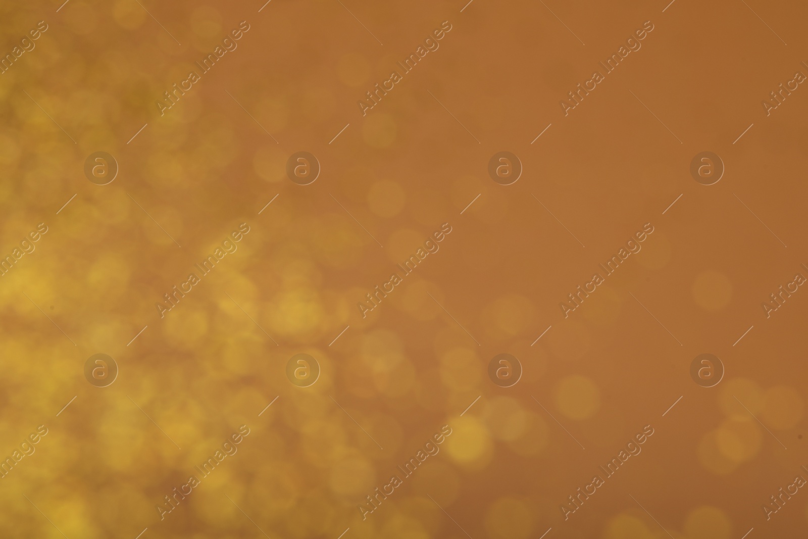 Photo of Blurred view of golden lights on brown background. Bokeh effect