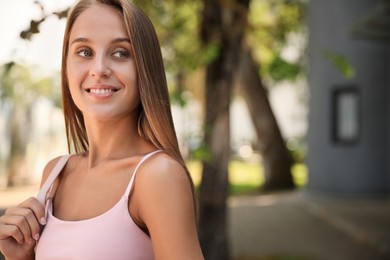 Photo of Portrait of beautiful young woman near building outdoors, space for text