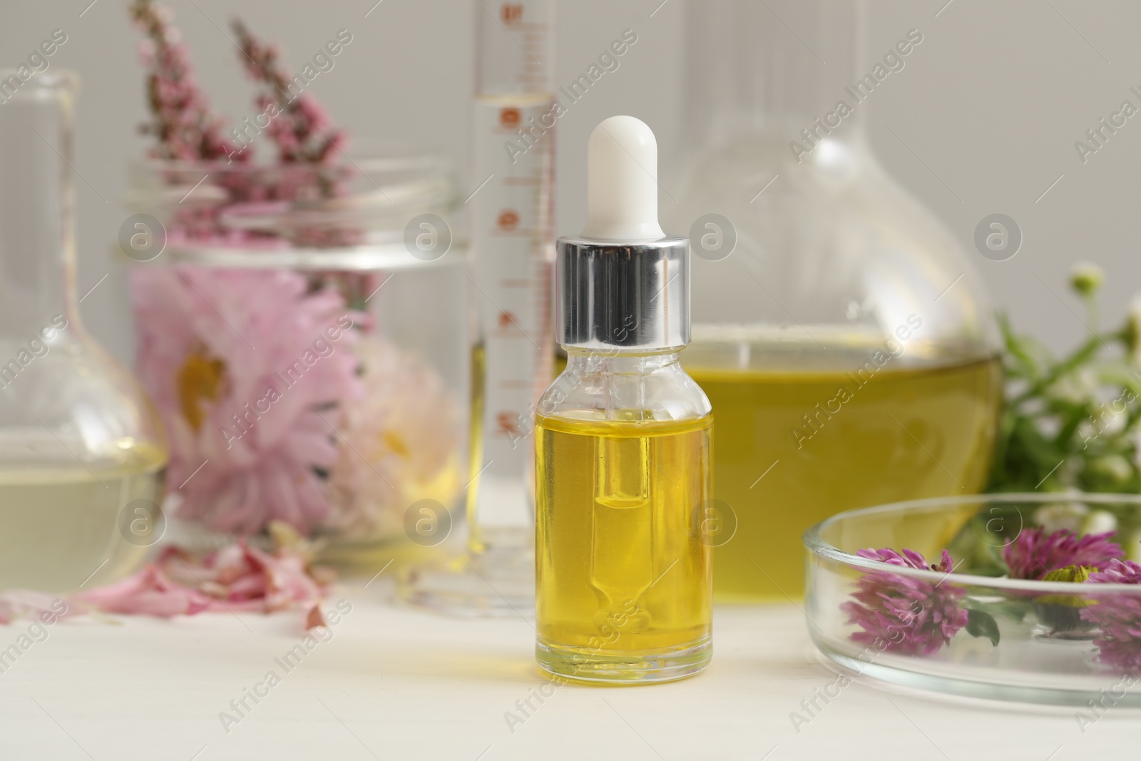 Photo of Bottle of cosmetic oil on white table, closeup