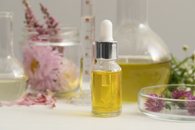 Bottle of cosmetic oil on white table, closeup