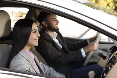 Photo of Young woman and driver in modern car