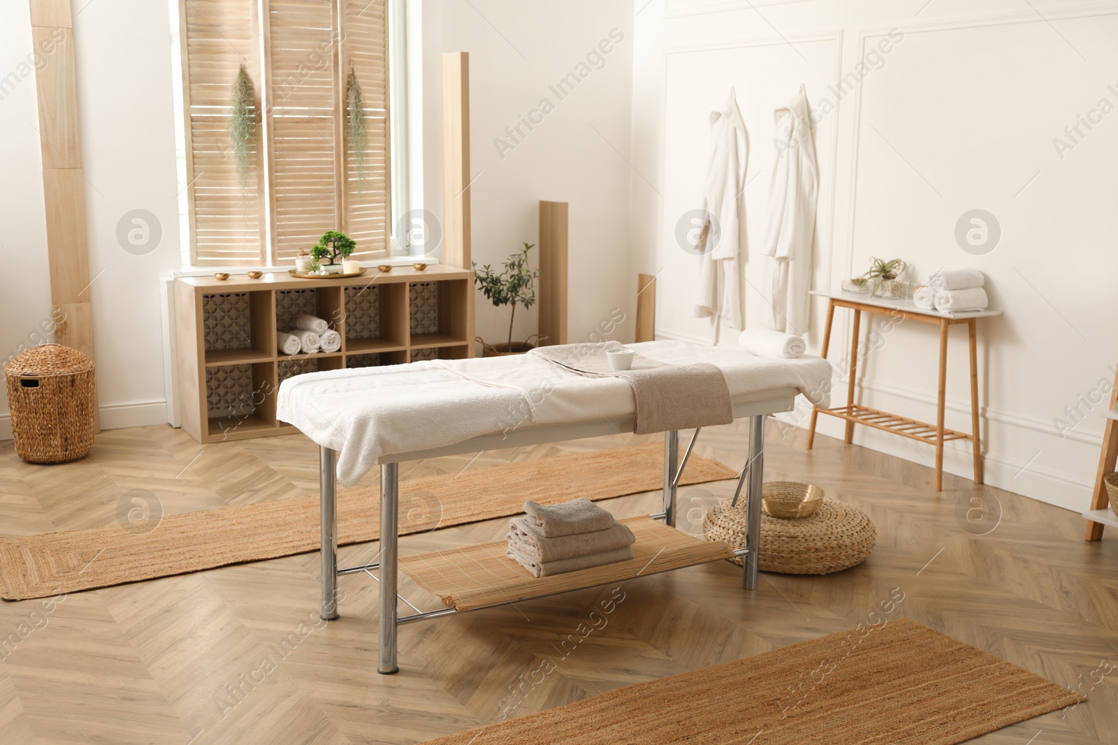 Photo of Stylish massage room interior with spa table in salon