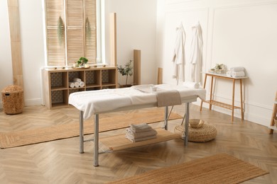 Stylish massage room interior with spa table in salon