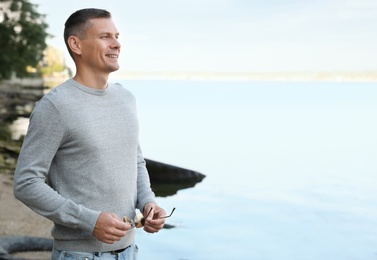 Photo of Happy man in stylish sweater on beach