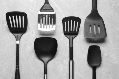 Photo of Different spatulas on grey marble table, flat lay