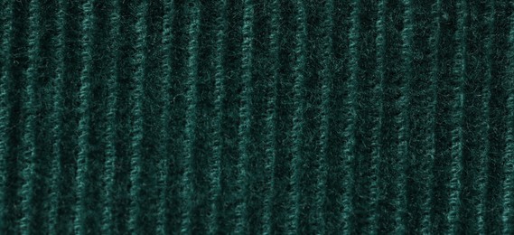 Texture of soft dark green knitted fabric as background, top view