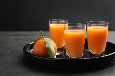 Delicious tangerine liqueur and fresh fruit on grey table