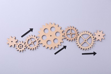 Business process organization and optimization. Scheme with wooden figures and arrows on lilac background, top view