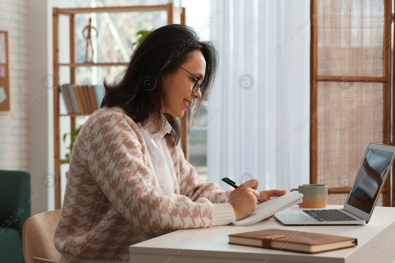 Photo of Woman with modern laptop learning at home