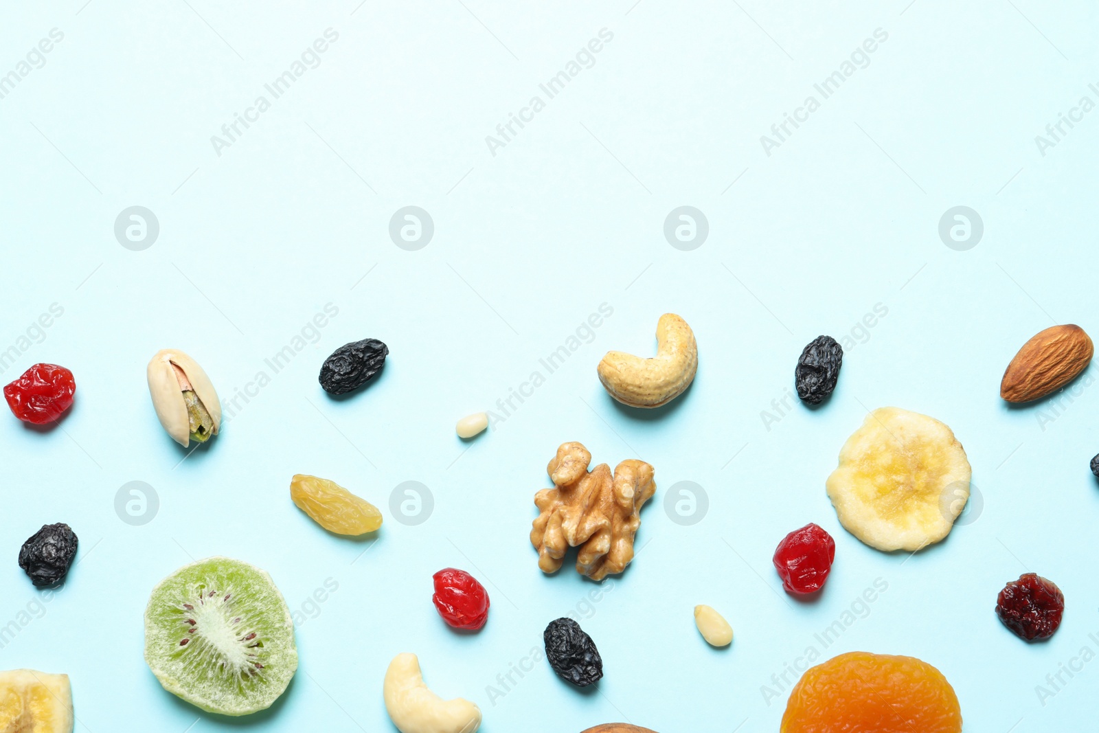 Photo of Flat lay composition of different dried fruits and nuts on color background. Space for text