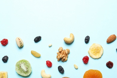 Flat lay composition of different dried fruits and nuts on color background. Space for text