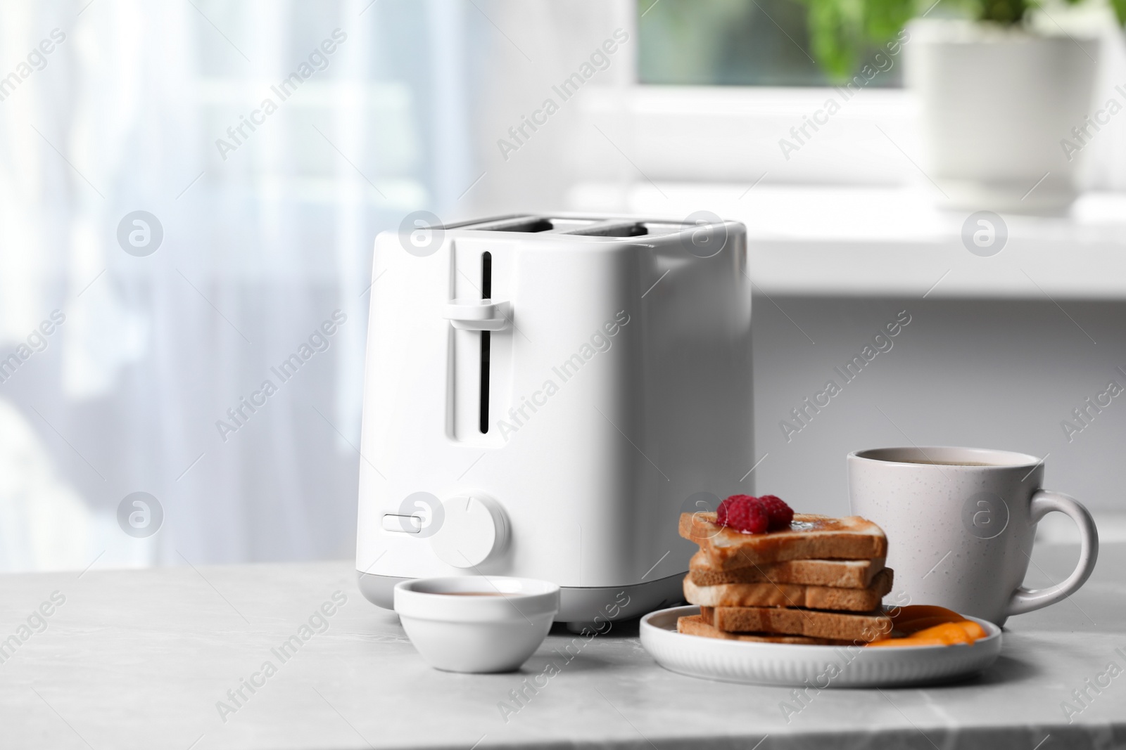 Photo of Toaster, roasted bread and coffee on light gray marble table, space for text. Tasty breakfast