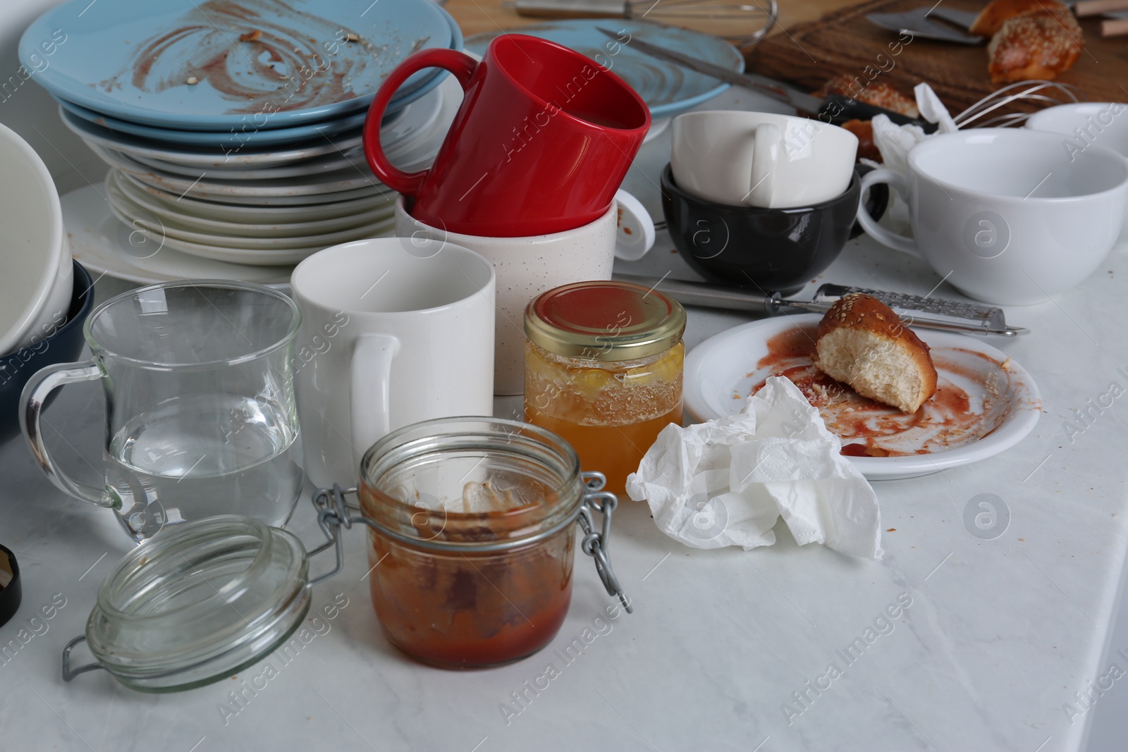 Photo of Many dirty utensils, dishware and food leftovers on countertop in messy kitchen