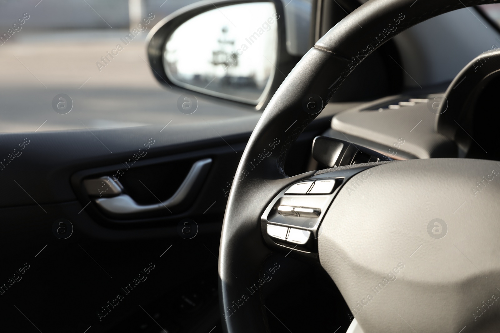 Photo of Black steering wheel inside of modern car, closeup. Space for text