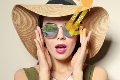 Image of Woman wearing sunglasses on light background. UVA and UVB rays reflected by lenses, illustration