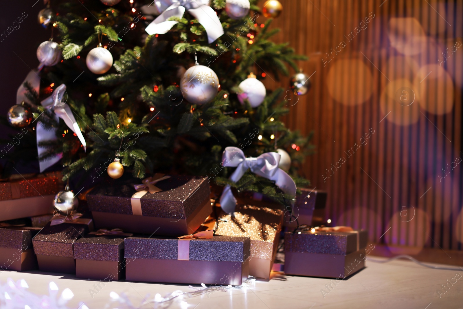 Photo of Beautiful Christmas tree and gift boxes in room