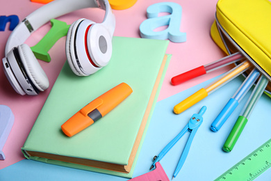 Photo of Book, headphones and stationery on color background