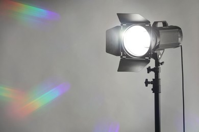 Grey photo background and professional lighting equipment in studio. Space for text