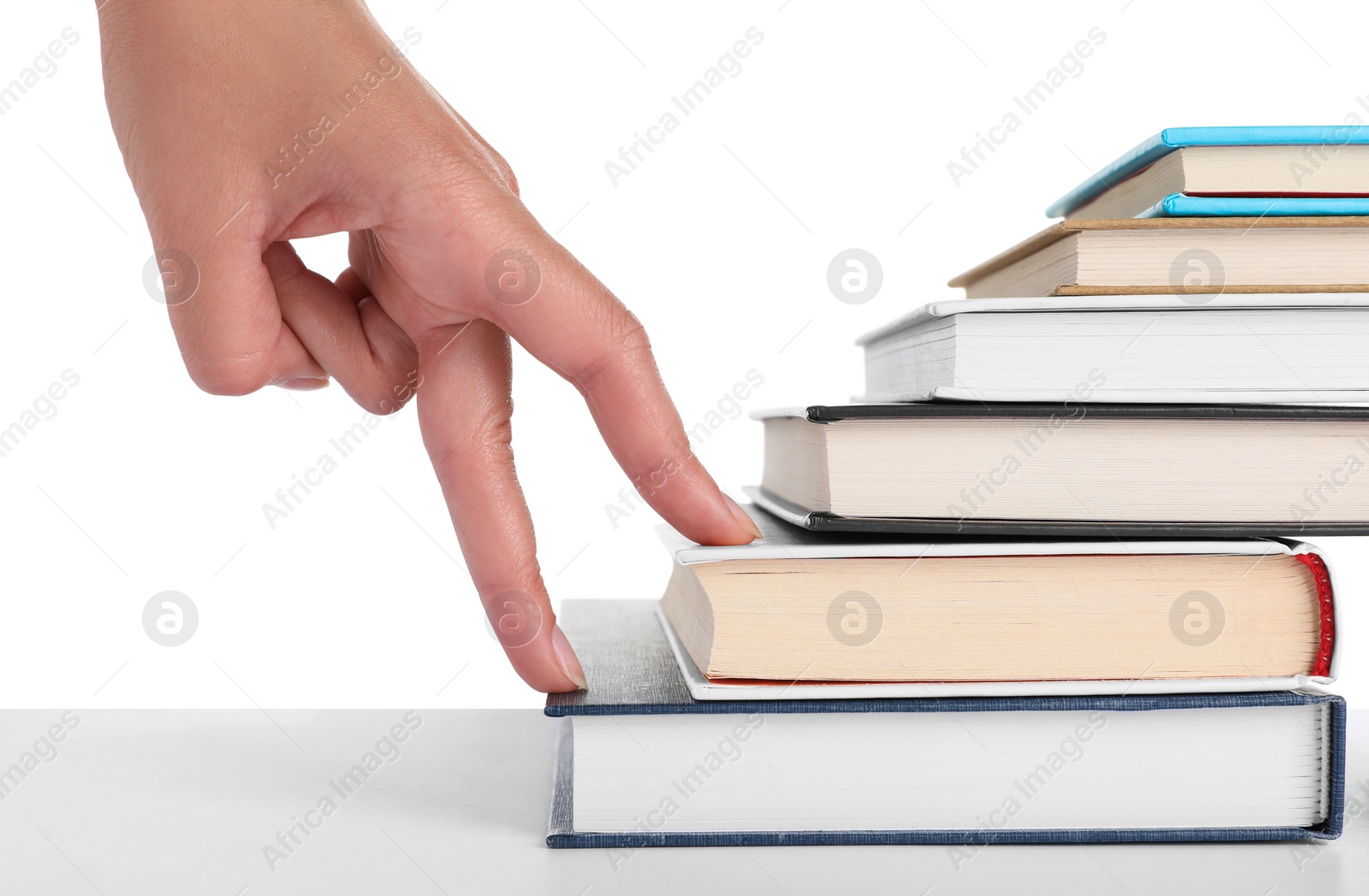 Photo of Woman imitating stepping up on books with her fingers against white background, closeup