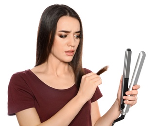 Emotional woman with hair iron on white background