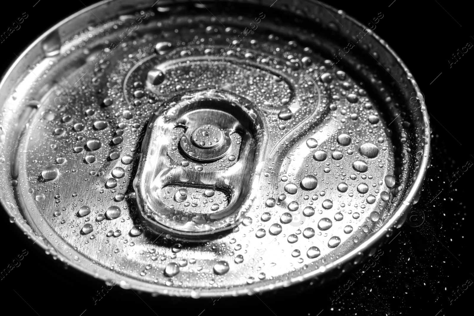 Photo of Aluminum can of beverage covered with water drops on black background, closeup