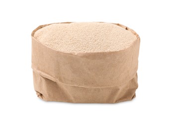 Granulated yeast in paper bag on white background