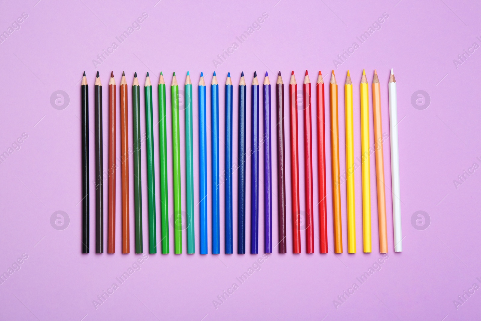 Photo of Color pencils on lilac background, flat lay