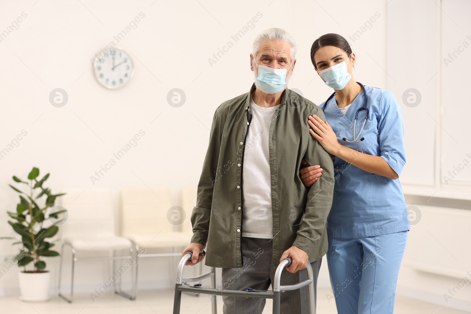 Photo of Young nurse with elderly patient in hospital, space for text
