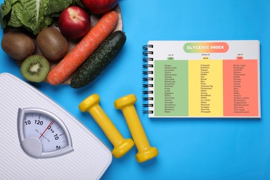 Glycemic index. Information about grouping of products under their GI in notebook, dumbbells, floor scale, fruits and vegetables on light blue background, flat lay