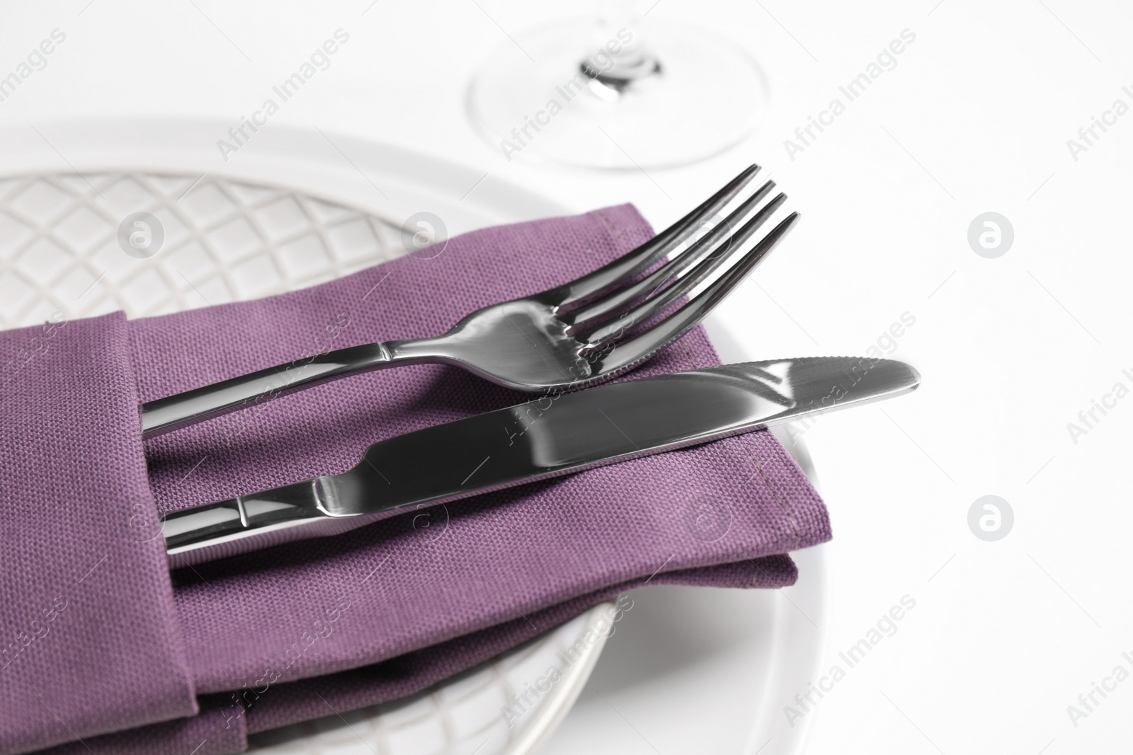 Photo of Plates with cutlery and napkin on white background, closeup. Table setting
