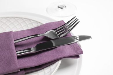 Photo of Plates with cutlery and napkin on white background, closeup. Table setting