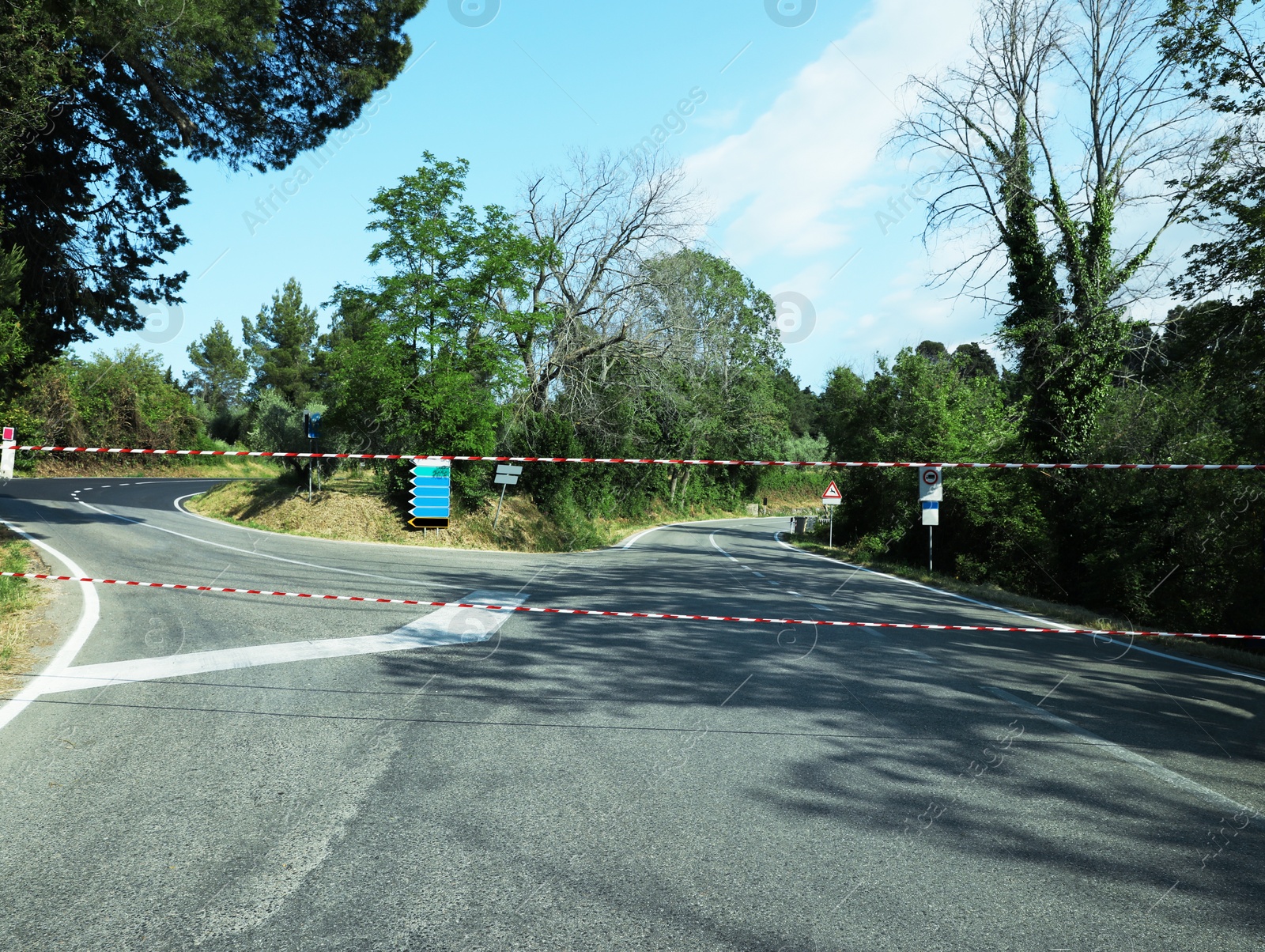 Photo of Construction tape over asphalt road on sunny day